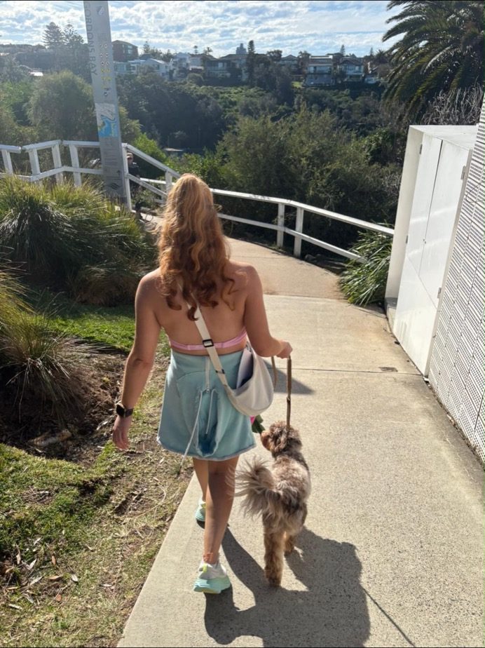 Nicole walking a dog along the coast